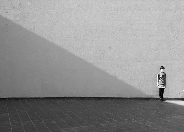 Rear view of woman standing against wall