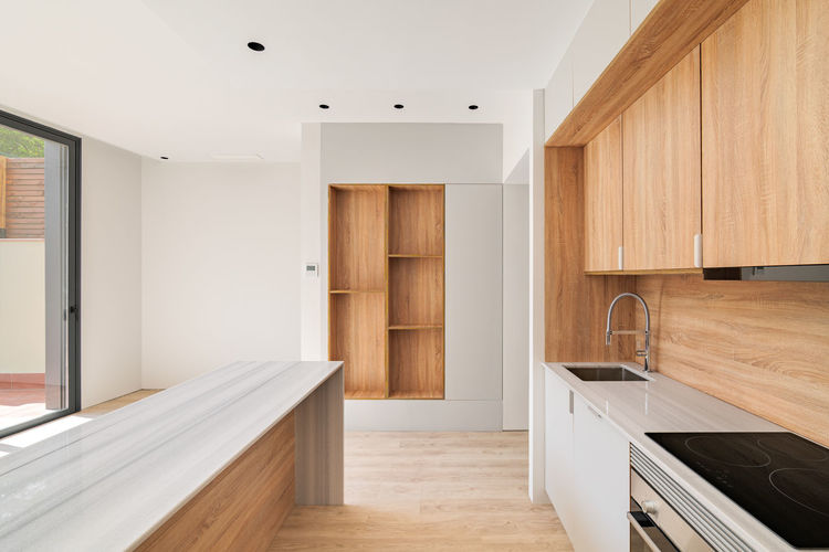 Modern kitchen interior with island and wooden furniture. empty interior of  refurbished apartment.