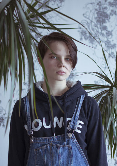 Portrait of young woman standing in park during foggy weather