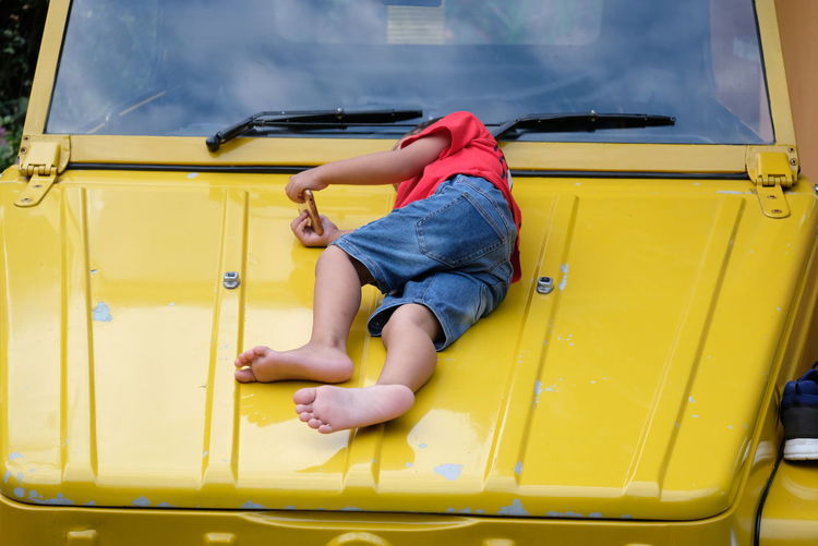 Rear view of boy lying in bus