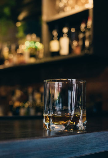 Close-up of whiskey glass on counter in bar