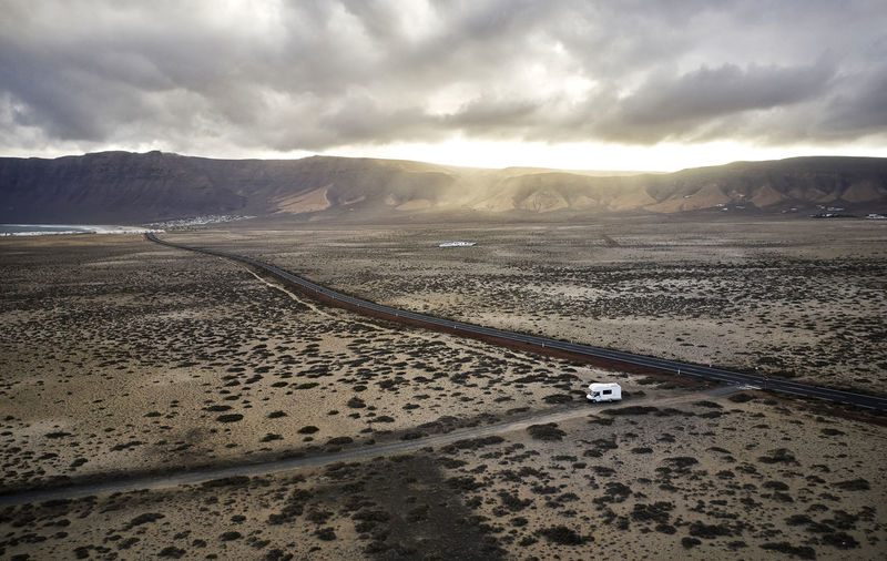 Spain, canary islands, aerial view of motor home driving along gravel road at lanzarote island