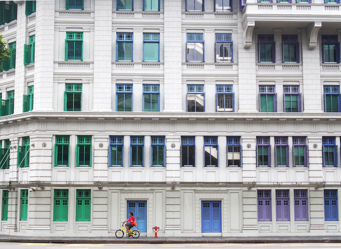 Man riding bicycle against buildings