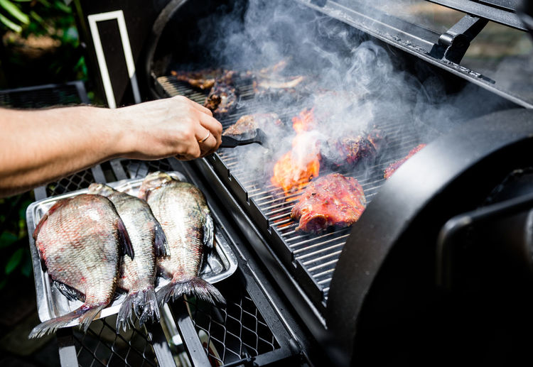 Close-up of man cooking on barbecue grill