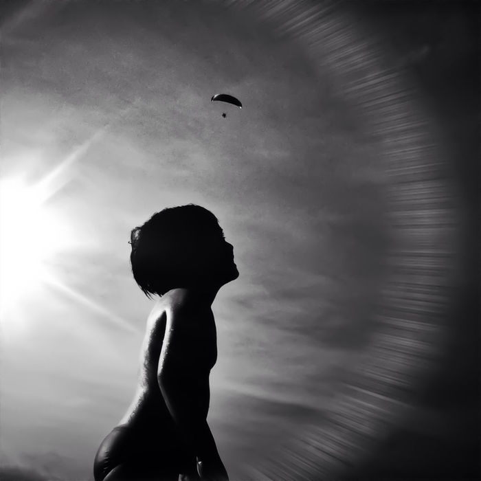 LOW ANGLE VIEW OF WOMAN STANDING AGAINST SKY