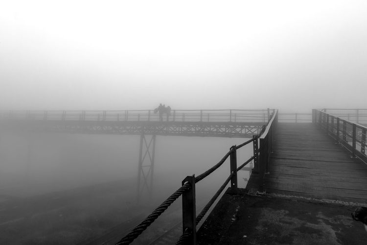 Bridge in foggy weather against sky