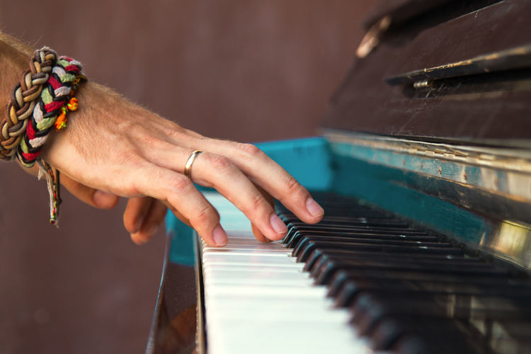 Close-up of man playing piano in home