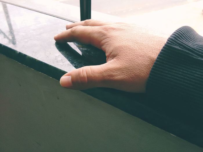 High angle view of person hand on window at home