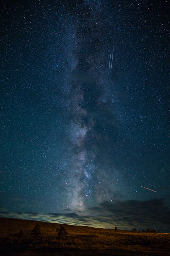 Scenic view of landscape against star field at night