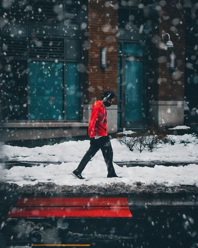 Full length of man on snow against buildings in city