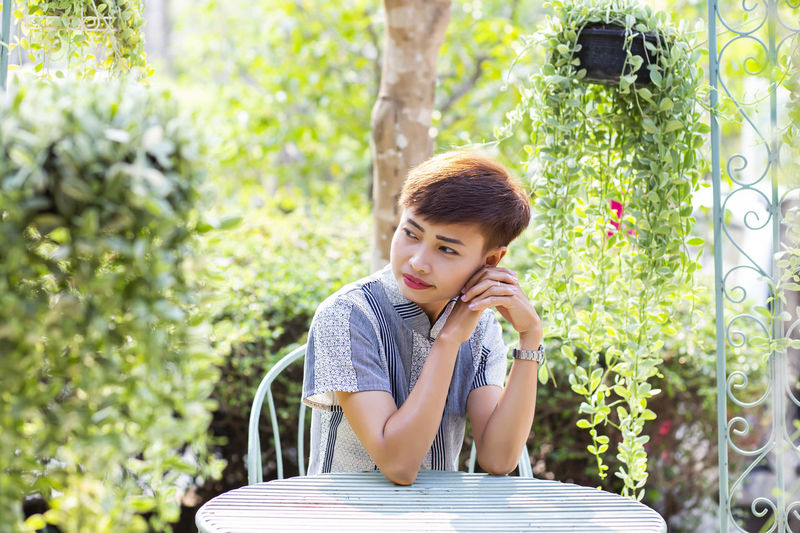 Boy looking away while sitting on table