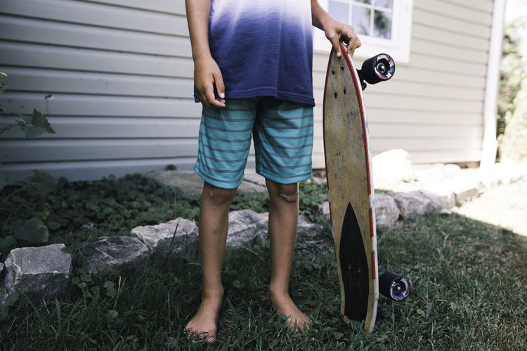 Faceless image of child holding skateboard