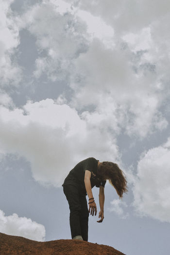 Side view of woman standing against sky
