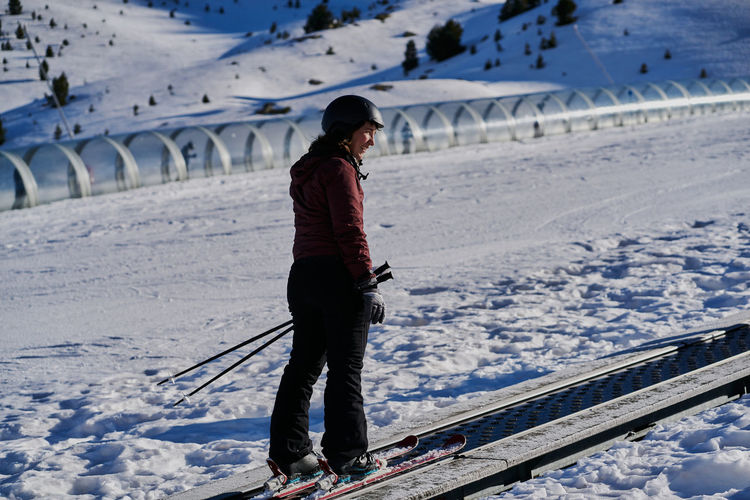 Smiling woman climbs the runway in a skier tape