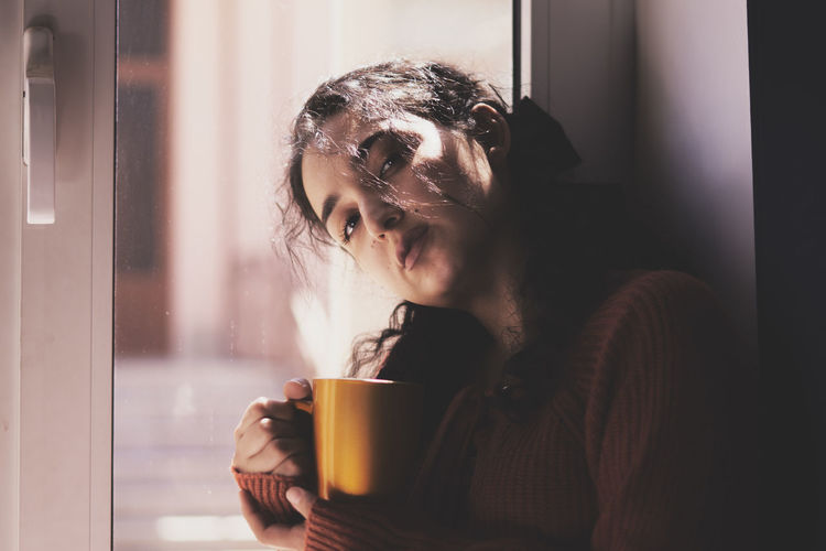 Young woman drinking coffee cup at home