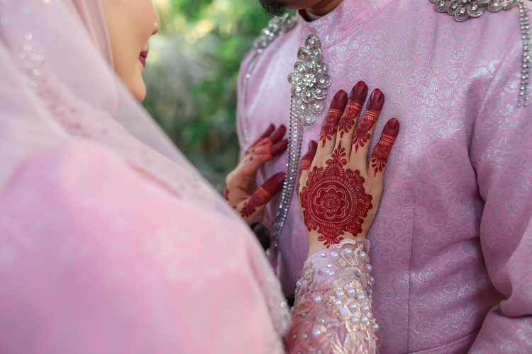 Midsection of bridge and groom during wedding ceremony 