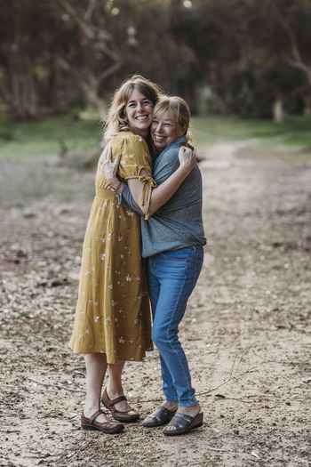 Portrait of adult woman and senior mother hugging at park