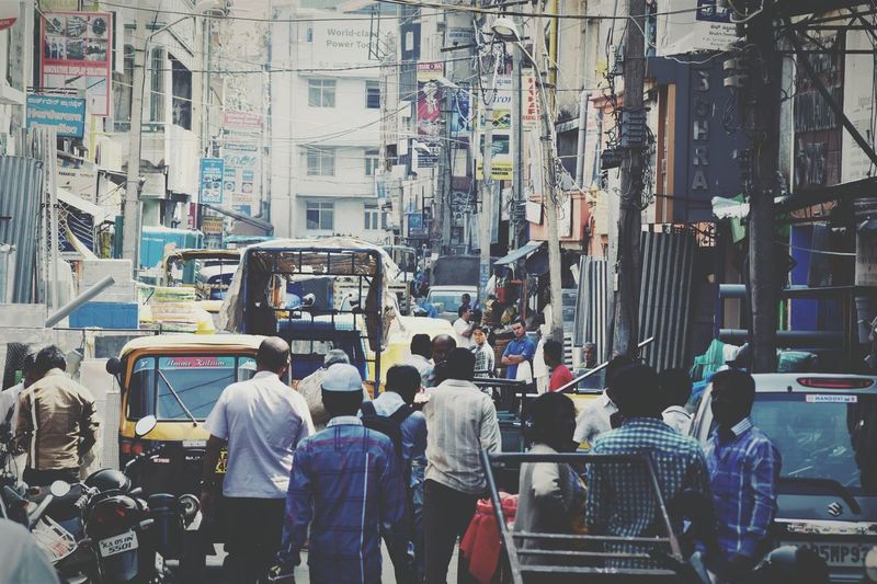 People on city street against buildings