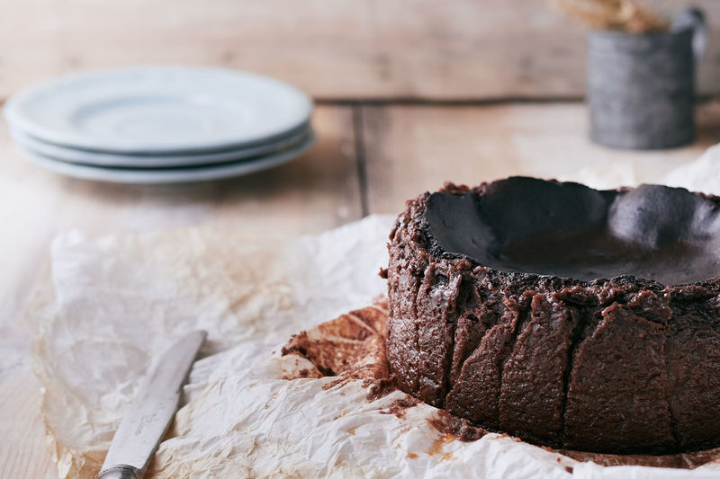 Chocolate basque cheesecake on a wooden table ready to serve