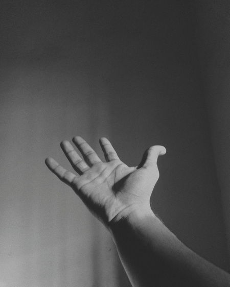 Close-up of human hand gesturing against wall