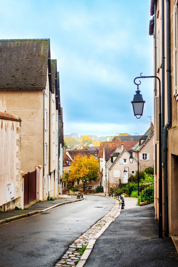Street amidst houses against sky