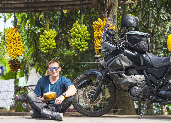 Motorbike rider enjoying local fruit, machala, el oro, ecuador