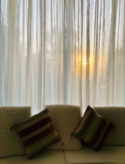 Open book on bed against window at home