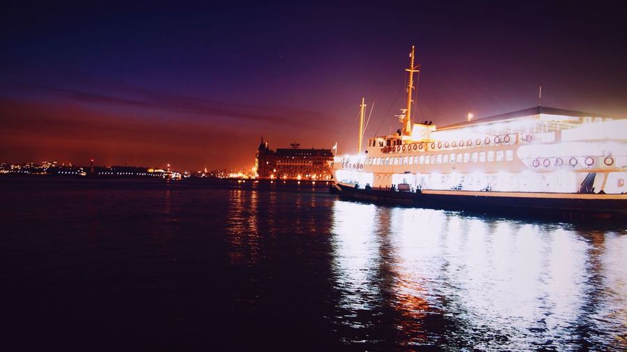 Illuminated ship on river during sunset
