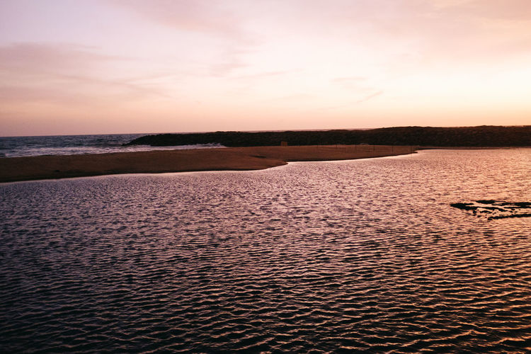 Scenic view of beach against sky during sunset