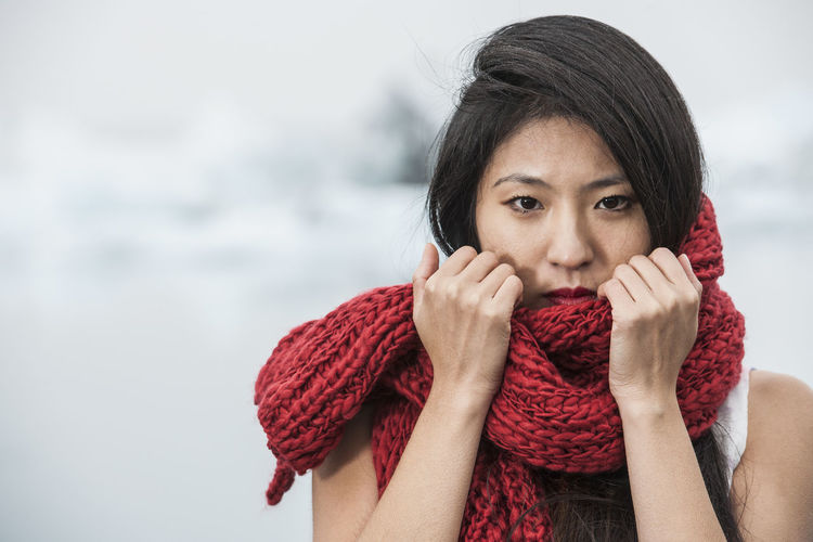 Portrait of young woman against red during winter