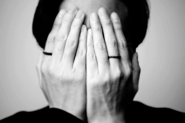 Close-up of woman covering face with hands