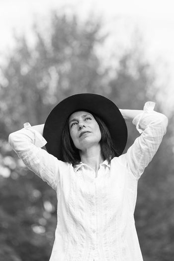 Young woman wearing hat standing against sky