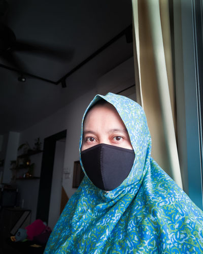 Portrait of woman wearing mask at home