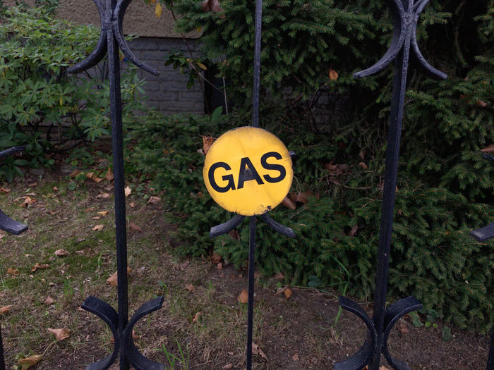 Close-up of yellow sign on fence
