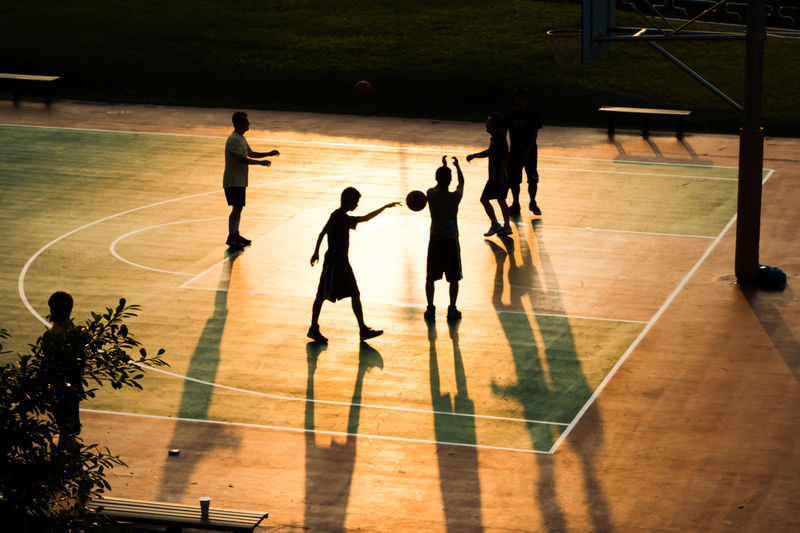 Silhouette boys playing basketball