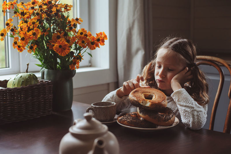 Cute girl having breakfast on table at home