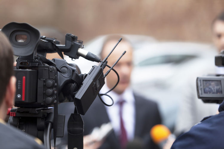 Cropped image of men filming news event with television cameras