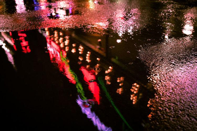 High angle view of illuminated wet street during rainy season