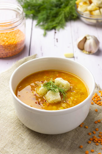 Red lentil soup with ingredients on a light background. traditional turkish or arabic spicy lentil