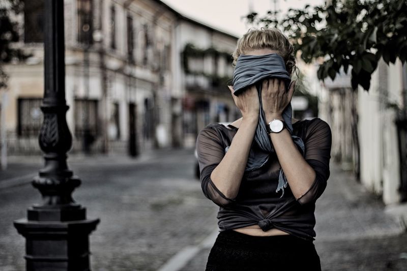 Young woman covering her face