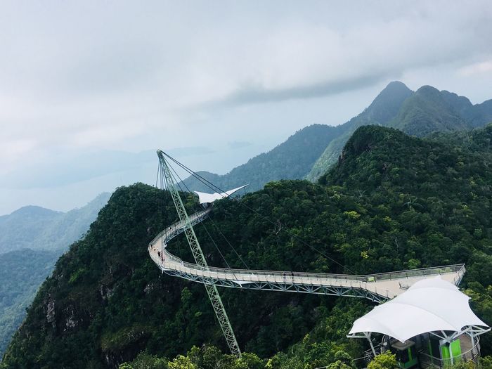 Scenic view of bridge over mountains against sky