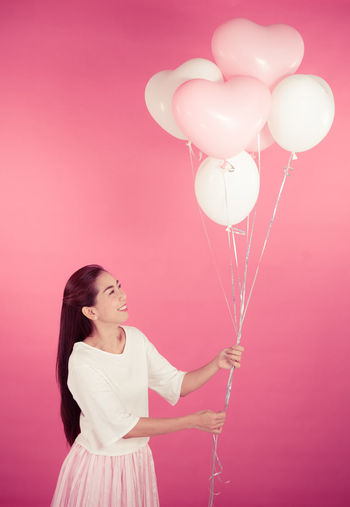 Full length of a young woman holding balloons