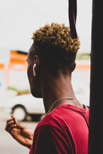 Rear view of young man wearing airpods standing on road