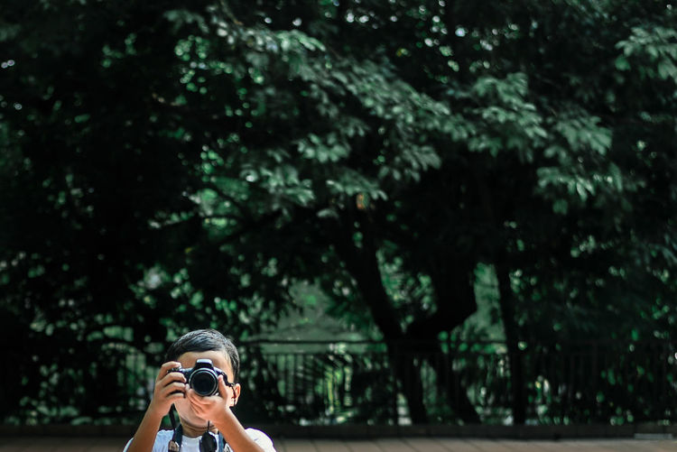 Young boy photographing in a park