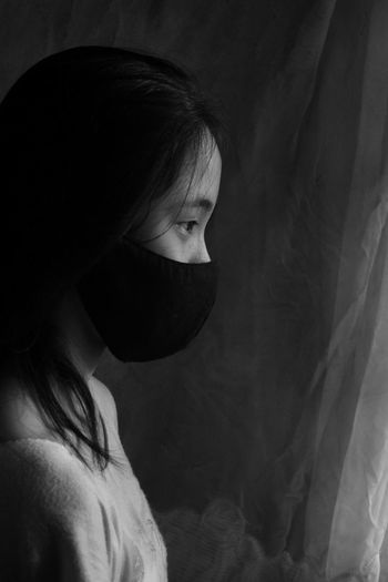 Side view of girl wearing mask looking away