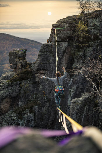 Mid adult woman balancing while highlining in mountains during sunset at baden-baden, germany