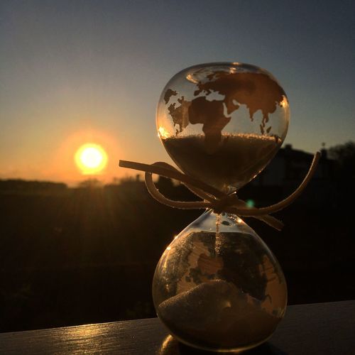 Close-up of crystal ball on table against sky during sunset