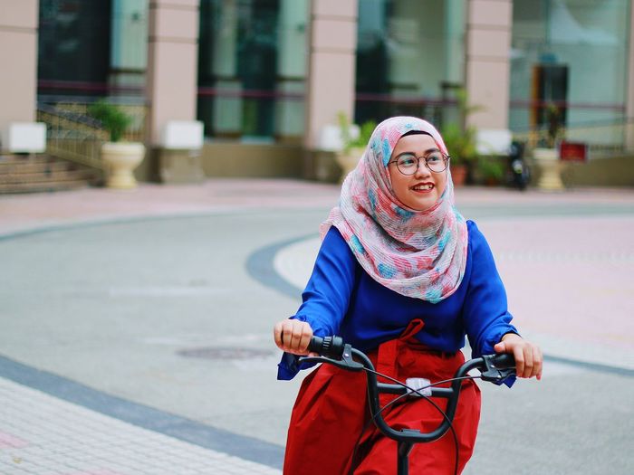 Close-up of young woman riding bicycle in city