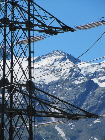 Low angle view of snow covered mountain against blue sky