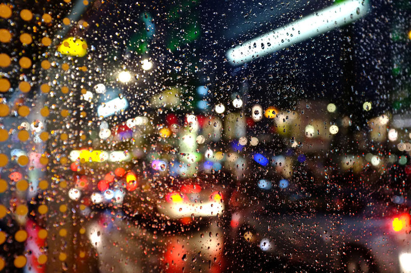 City seen through wet glass window at night